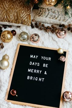 a black board that says may your days be merry and bright surrounded by christmas ornaments