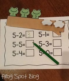 a piece of paper that has been cut out to look like a number line with frogs on it