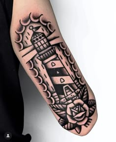 a man's arm with a lighthouse tattoo on it