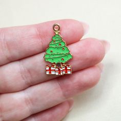 These Christmas tree with presents charms are made of a golden, zinc-based alloy completed with enamel coloring. They are approximately 28.5mm x 16.5mm big. The hole size is 1.8mm wide and they are 1mm thick. NOTE: Please remember the color may vary on different devices. If you would like to see a different picture before purchasing, feel free to message me and I would be happy to send you one. You can purchase them as a set of 5, 10, or 20. Christmas Tree With Presents, Christmas Charms, Cute Snowman, Charm Set, Gold Enamel, Free Gifts, Gift Registry, Charms, Etsy Gifts