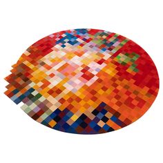 a round rug with multicolored squares in the center on a white background,