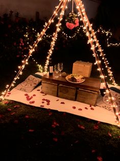 a teepee with lights on it and some wine glasses sitting in front of it