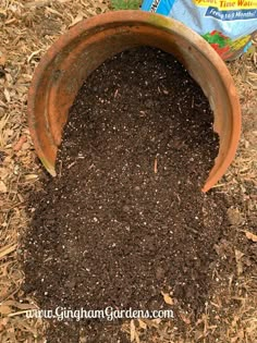 a brown pot filled with dirt next to a bag of chips