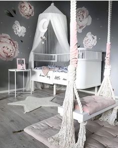 a white canopy bed with pink flowers on the wall