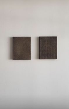 two square pieces of cloth hanging on the wall