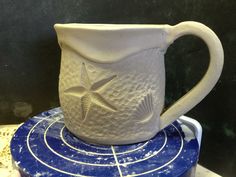 a white mug sitting on top of a blue coaster