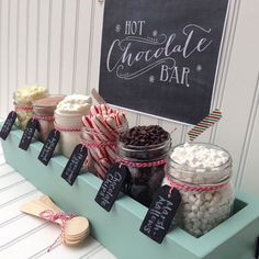 an assortment of desserts are displayed on a table with a chalkboard sign in the background