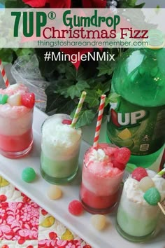 four cups filled with drinks sitting on top of a white tray next to green bottles