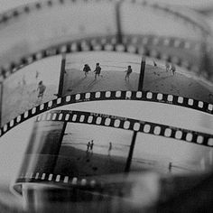 black and white photograph of film strips with people walking on the beach in the background