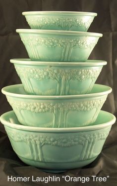 four green glass bowls stacked on top of each other