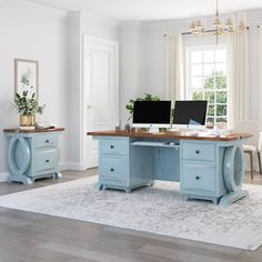 a desk with two computer monitors on top of it next to a chair and rug