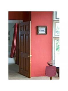 an open door leading to a bedroom with pink walls