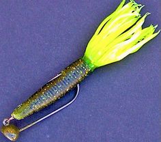 a green and yellow fishing lure on a blue surface