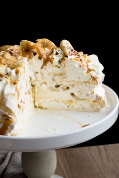 a piece of cake on a white plate with caramel drizzle and nuts