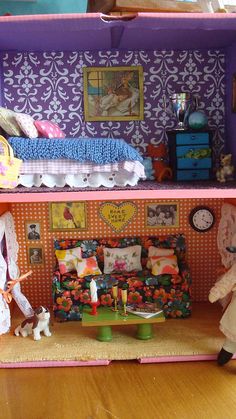 a doll house with furniture and accessories in the room, as well as two dolls