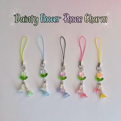 five different colored flower phone charms hanging on a white background with the words, dainty flower phone charm