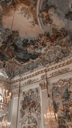 an ornate ceiling with paintings and chandeliers in a room that is painted white