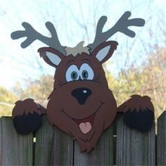 a paper cut out of a reindeer with antlers on it's head over a wooden fence