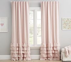 a pink curtain with ruffled edges in front of a white chair and pictures on the wall