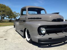 an old gray truck parked in a parking lot