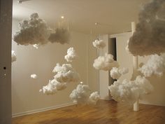 there are clouds floating in the air over a wood floor