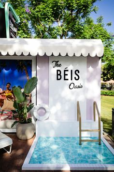 an outdoor pool area with a sign that says the belis oasis