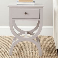 a white table with a book on top of it and a chair in the background