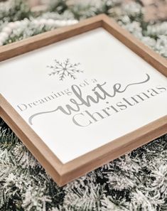 a white christmas sign sitting on top of snow covered ground