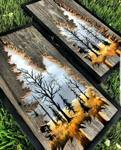 two wooden boards with trees painted on them