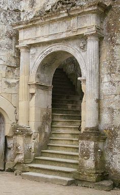 an old stone building with stairs leading up to it