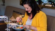 a woman sitting at a table with a bowl of food