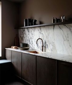 a kitchen with marble counter tops and wooden cabinets