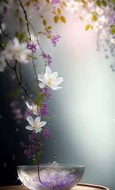 a bowl filled with flowers on top of a wooden table next to a tree branch