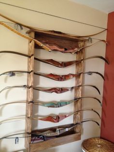 a wooden shelf with many different types of bow bows on it's sides, hanging from the wall