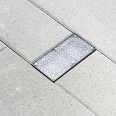 a metal grate sitting on the side of a sidewalk