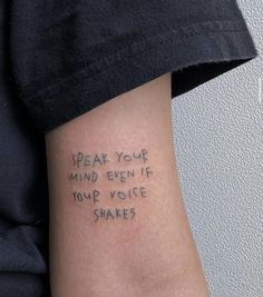 someone with a tattoo on their arm that says speak your mind even if your voice shakes