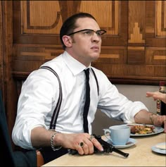 a man sitting at a table with a plate of food in front of him