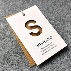 a card with the letter s on it sitting on top of a gray carpeted floor