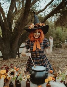 a woman with red hair wearing a witches hat and holding a caulder in her hand