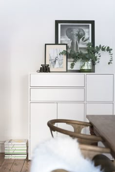 a white cabinet and table with pictures on it