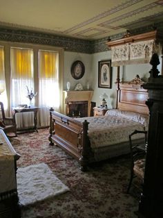 an old fashioned bedroom with antique furniture and paintings on the walls, along with two fireplaces