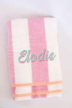 a towel with the name elodlie on it sitting next to a white wall