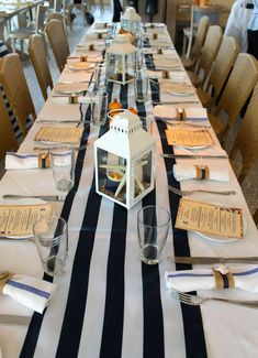 a long table set with place settings and napkins for guests to sit down at