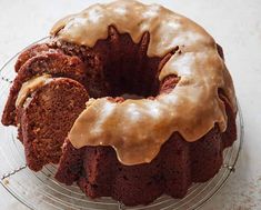 a chocolate bundt cake with icing on a glass plate