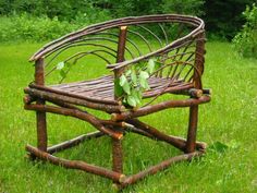 a chair made out of branches in the grass