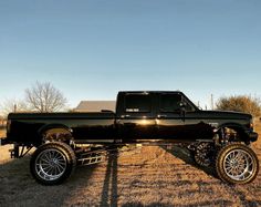 a black pickup truck parked on top of a dry grass field