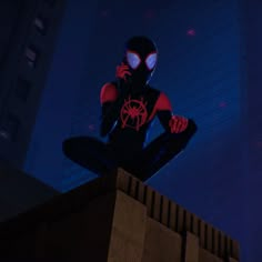 a spider man sitting on top of a building