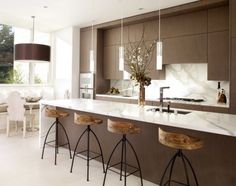 a kitchen with marble counter tops and bar stools