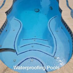 an empty swimming pool with blue tiles on the floor and water running down it's sides