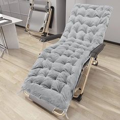 a gray couch sitting on top of a hard wood floor next to a white desk